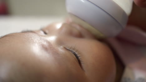 adorable baby girl being bottle fed
