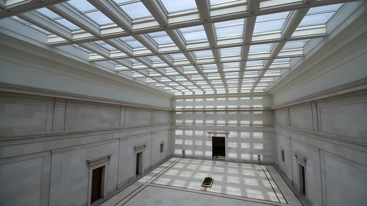Luce solare che filtra attraverso il lucernario proiettando ombre a scacchiera sul pavimento della galleria, piedistallo scuro