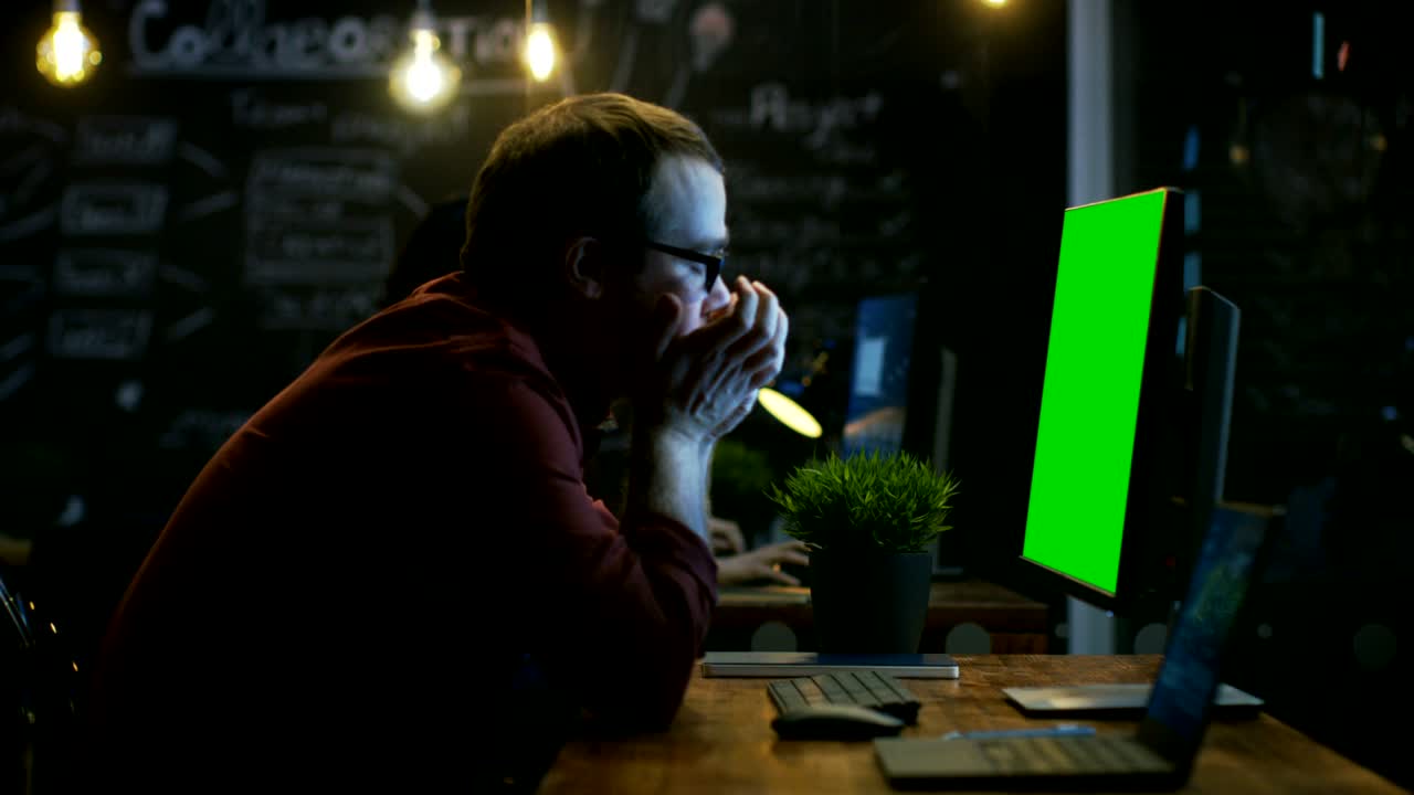 Stressed Office Worker, Exhales and Hits the Table with His Fist in Frustration and Covers His Face in Hands. He's Working on a Personal Computer with Mock-up Green Screen.