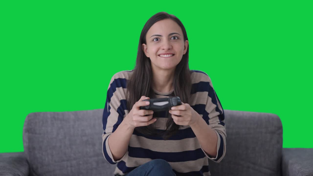 chica india competitiva jugando videojuegos pantalla verde