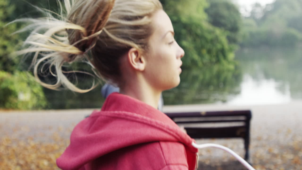 웨어러블 기술과 연결된 장치를 착용한 공원에서 달리는 운동 부부