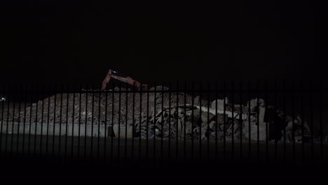 concrete rubble and excavator at night - wide