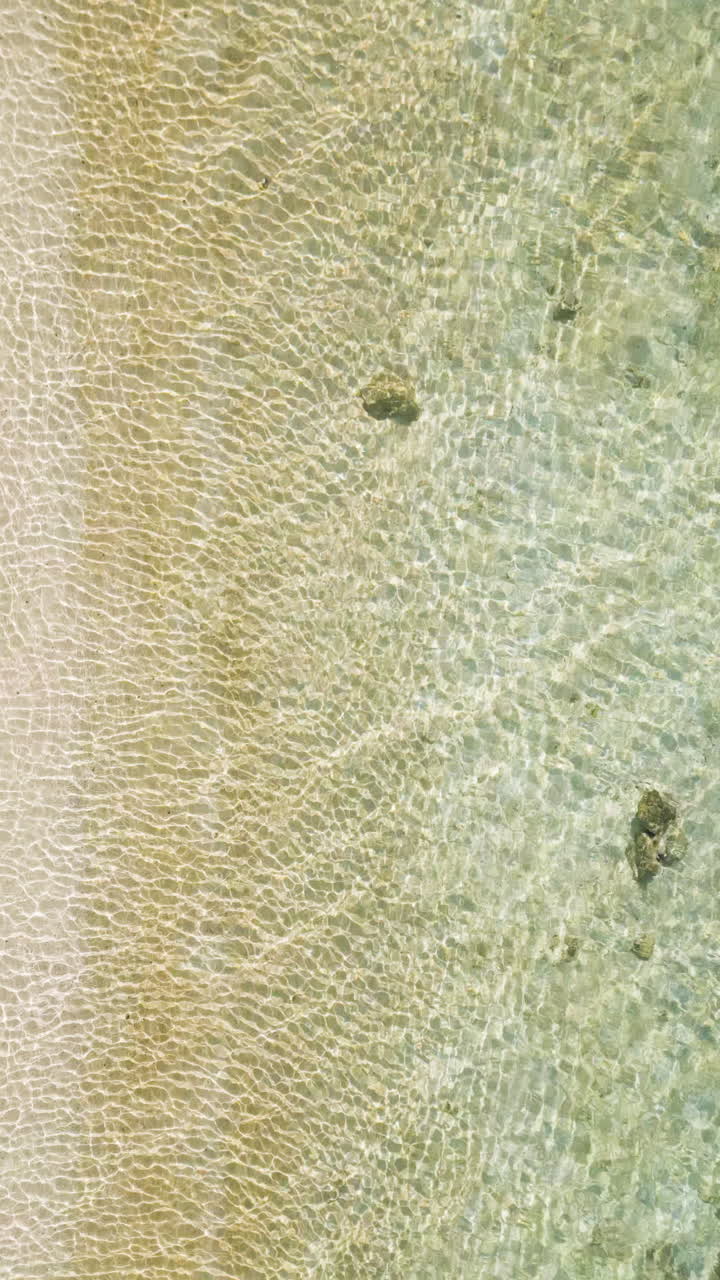 Aerial Top View Of Seascape With Crystal Clear Water At Beach In Summer. vertical shot