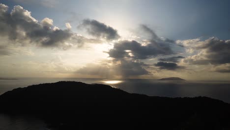 timelapse del amanecer con rayos de sol a través de las nubes desde la cima de una montaña