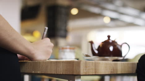 Close-up-hands-showing-business-plan-in-cafe