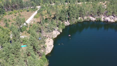 aerial drone video of a large lake surrounded by a pine tree forest in kyiv oblast ukraine on a hot sunny summer day