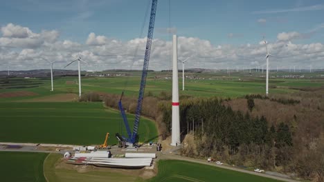 wind turbine blades and windmill parts in the construction site - aerial drone shot