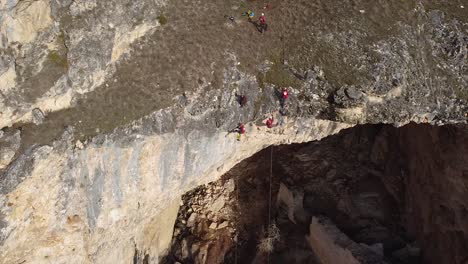 aerial shot of emergency team climbing down a big rock in a rescue mission