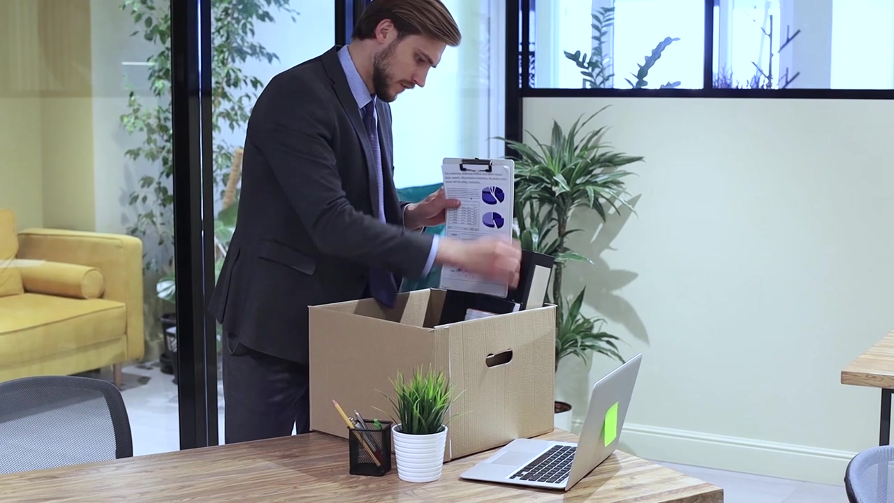 Businessman Packing Personal Items into a Box and Leaving Office