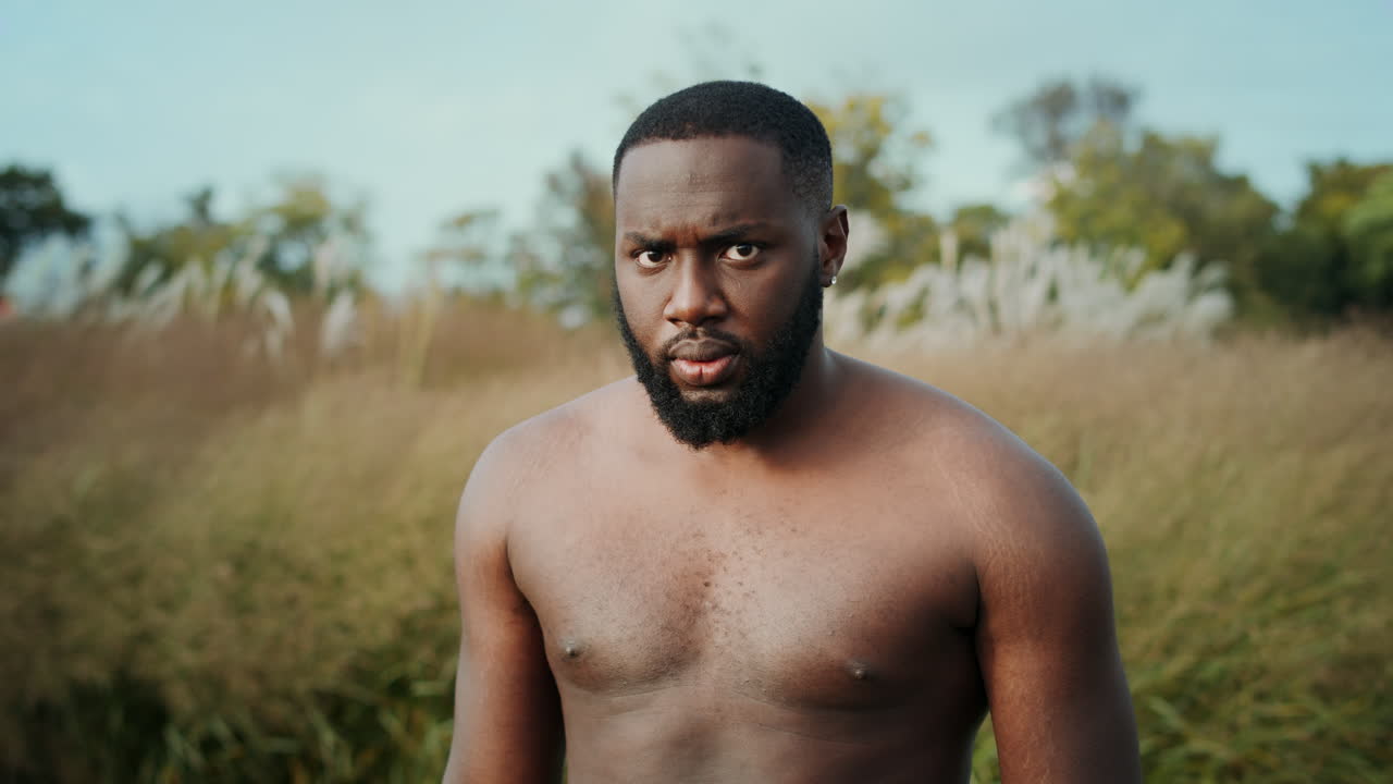 hombre musculoso posando en la cámara al aire libre