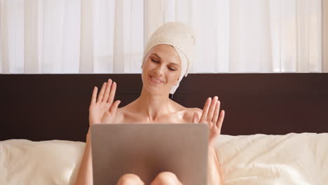 woman enjoying a video call in bed after her morning routine