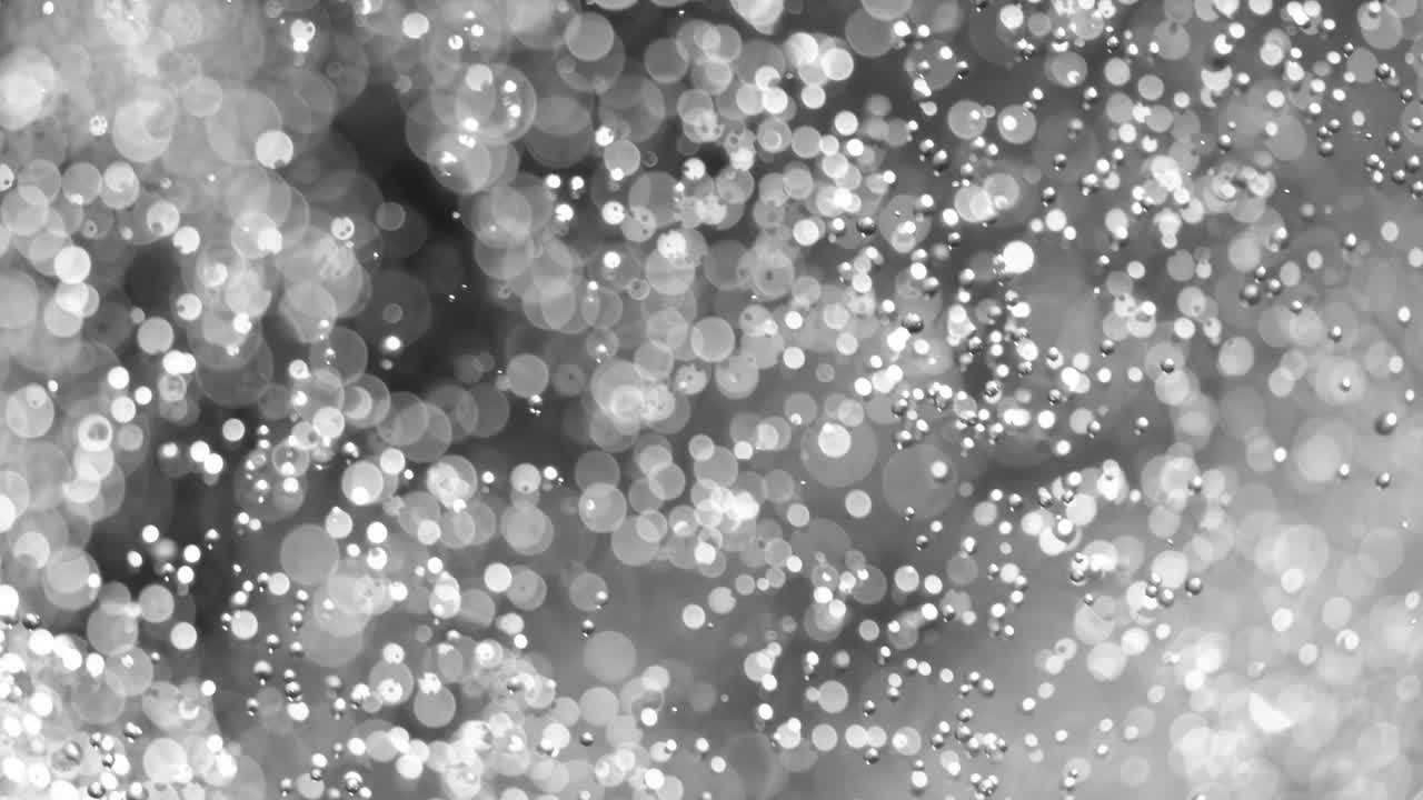 Floating abstract particle bokeh on dark background. Shot on super slow motion camera 1000 fps.