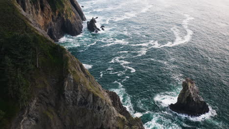 Vista-Aérea-Sobre-Acantilados-Rocosos-Azotados-Por-El-Turbulento-Océano-Pacífico,-Costa-De-Oregon