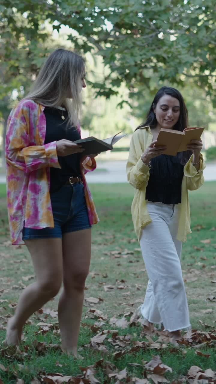 Two women reading books in a park