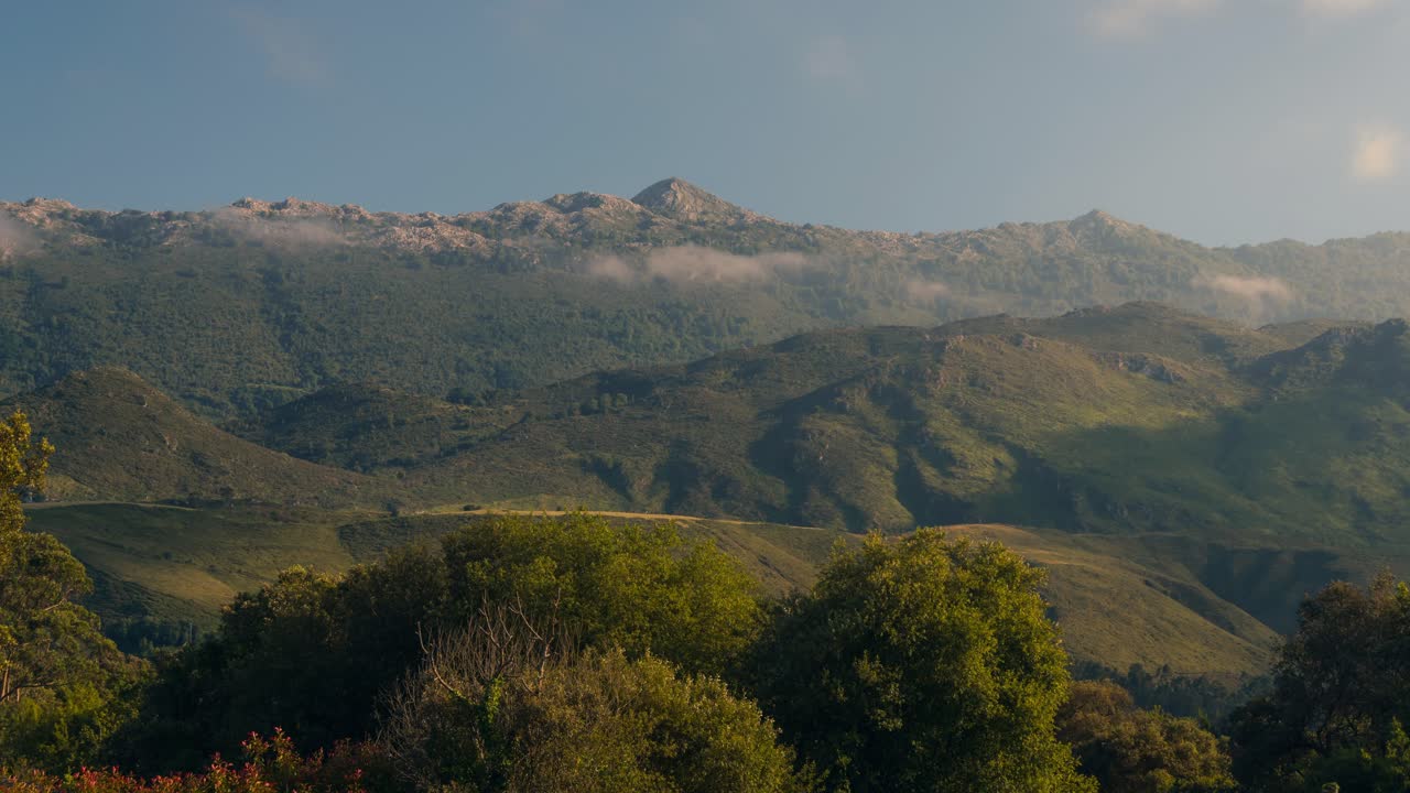 sierra de cuera vista desde andrin, llanes durante una tarde soleada con nubes bajas y una hermosa luz jugando con las montañas