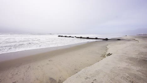wide view of rough waves ocean approaching camera on beach on a gloomy day in ocnj