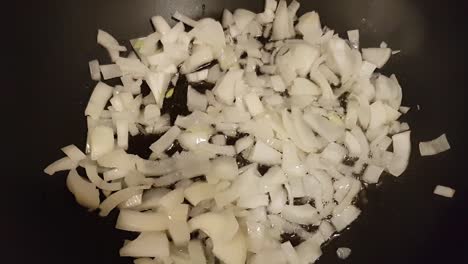 frying red onion slices in a pan