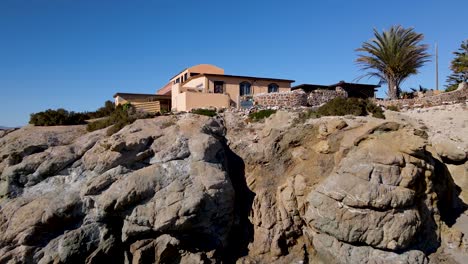 Rising-aerial-dolly-over-tropical-mexican-villa-house-on-seacliff-reveal