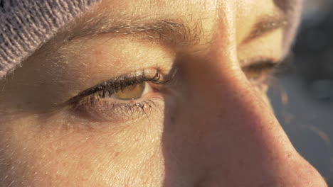 macro primer plano de una mujer abriendo los ojos en cámara lenta con iluminación dorada de puesta de sol