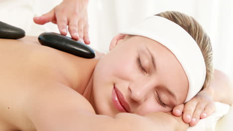 Smiling-blonde-getting-hot-stone-massage