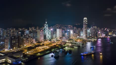 witness the breathtaking skyline of hong kong illuminated at night, showcasing vibrant city lights and bustling harbor activities. the scene captures beautiful architecture and a lively atmosphere.