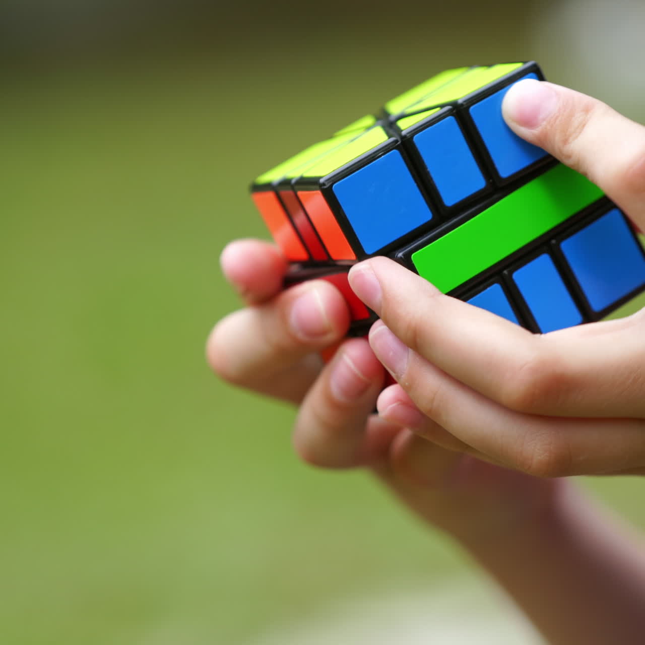 Boy practices with difficult Rubik's Cube. Smart teenager solving puzzle game with new Rubik's cube. Concept of problem solving, solution, focus and goal.