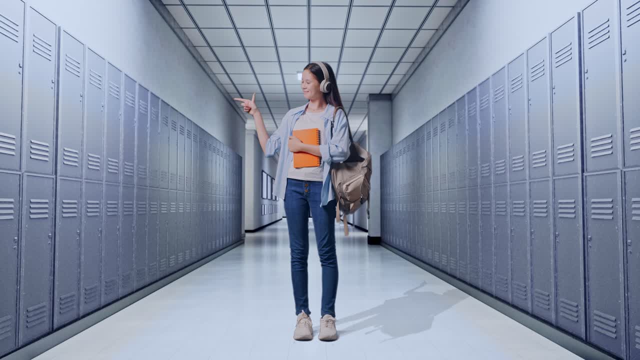 cuerpo lleno de estudiante adolescente asiática con una mochila y algunos libros sonriendo y señalando a un lado mientras estaba de pie en el pasillo