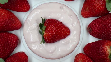deliciosas fresas frescas, yogur de fresa, en una pantalla giratoria
