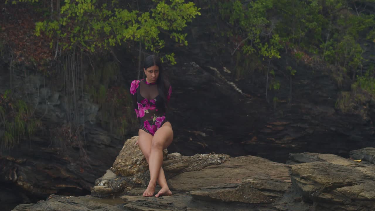 Witness a Latin girl in lingerie on a cliffside beach in the Caribbean.