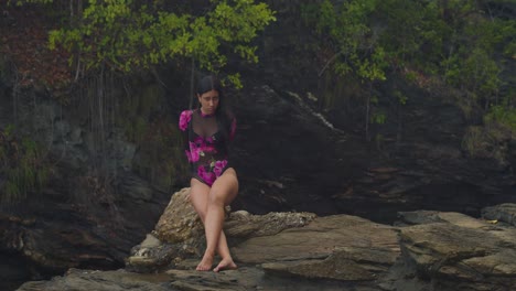 witness a latin girl in lingerie on a cliffside beach in the caribbean.