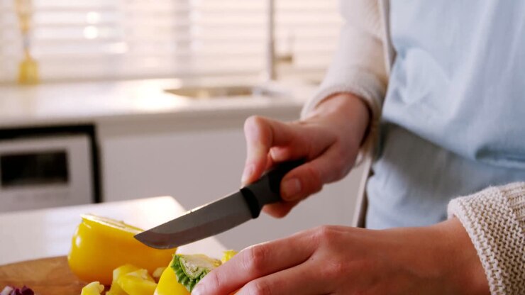 Woman cutting red cabbage in kitchen