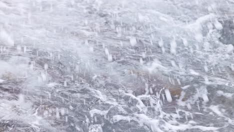 dynamic ocean waves crash against a rocky, seaweed-covered shore. captured with natural lighting, showcasing the power of nature