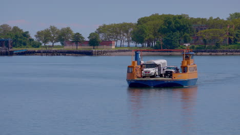 orange roll-on, roll-off ferry leaving the prison dock at hart island, with white prison bus