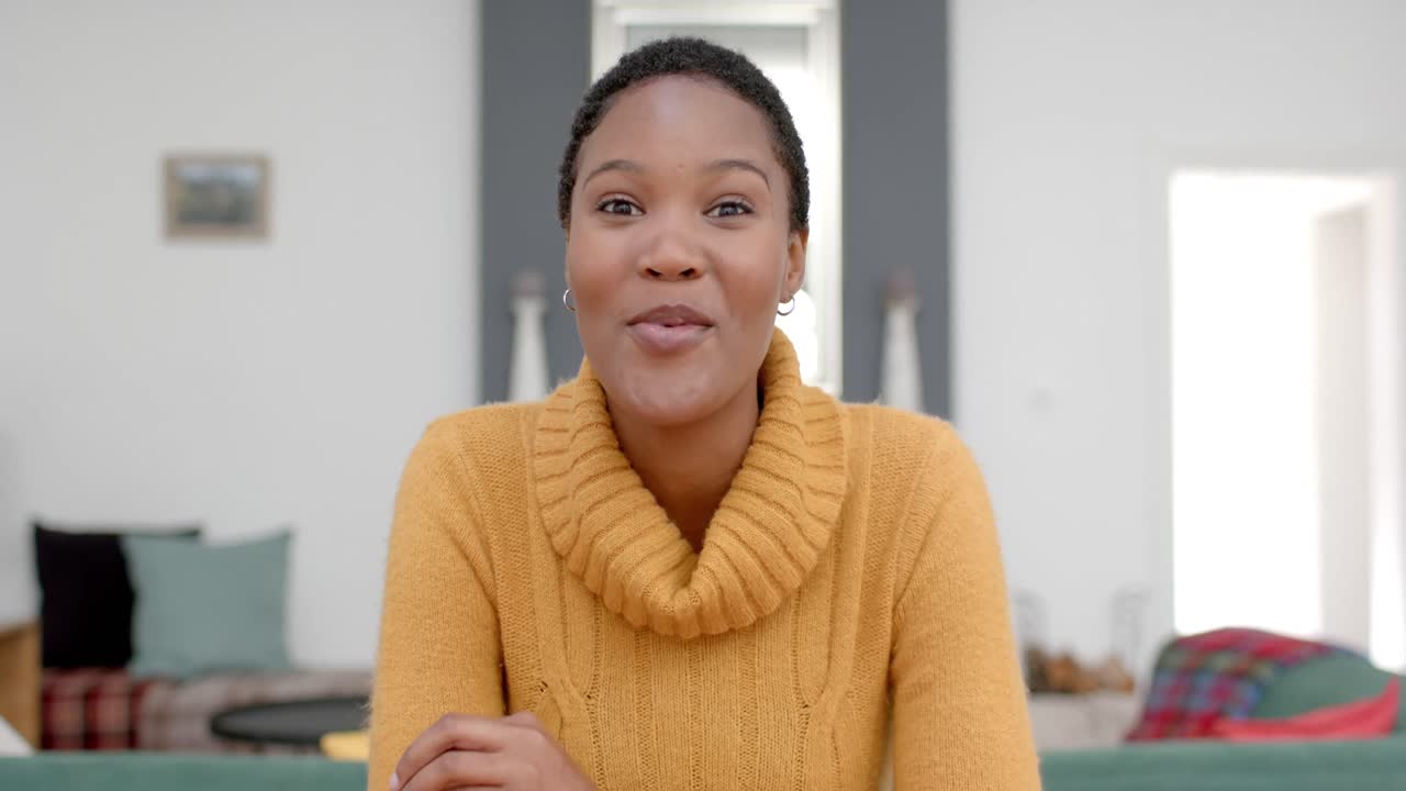Felice donna afroamericana che fa una videochiamata a casa, al rallentatore.