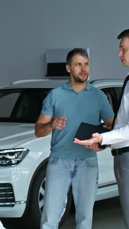 vendedor de coches discutiendo un coche con un cliente