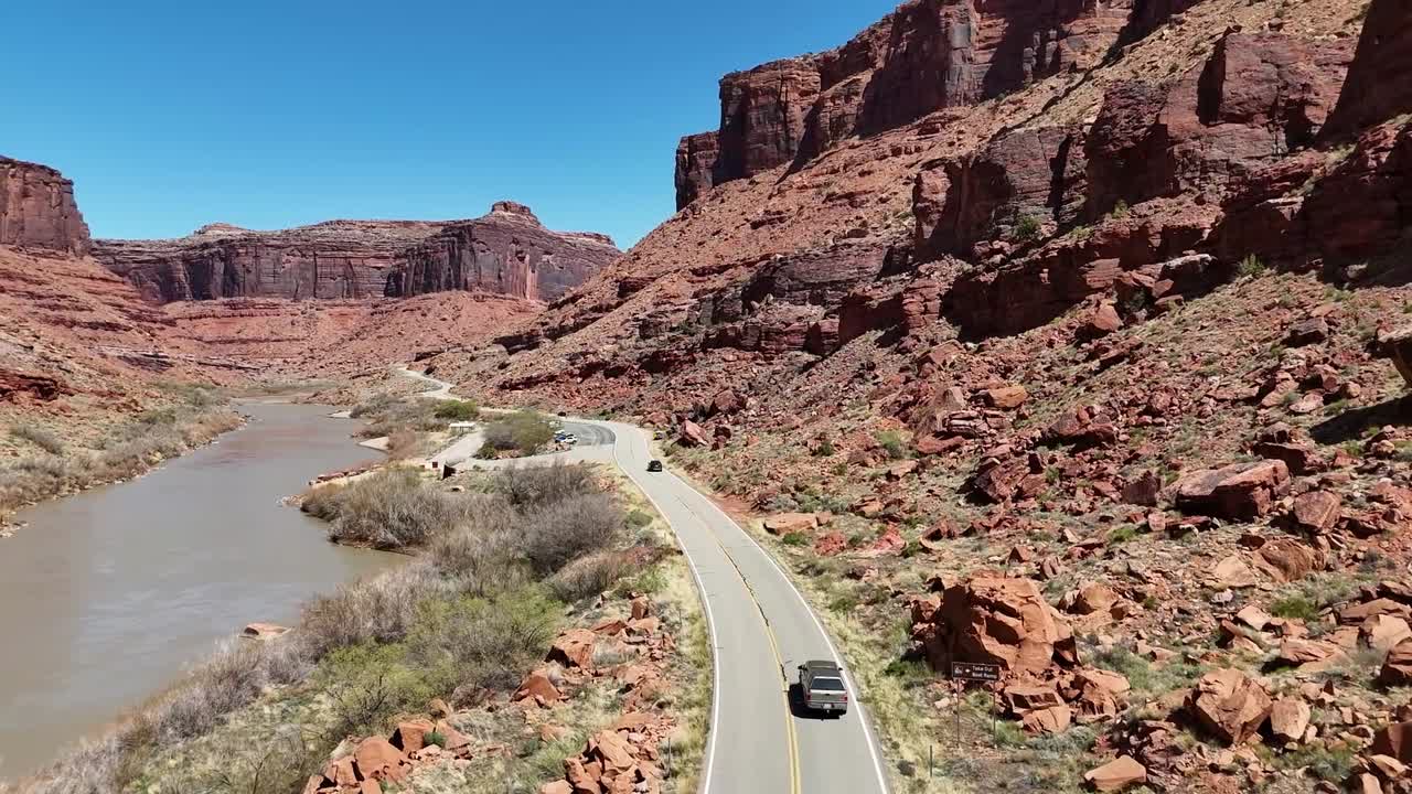 Aerial View of Car Driving Down Highway in Canyon, Highway 128 in Moab Utah, Colorado River