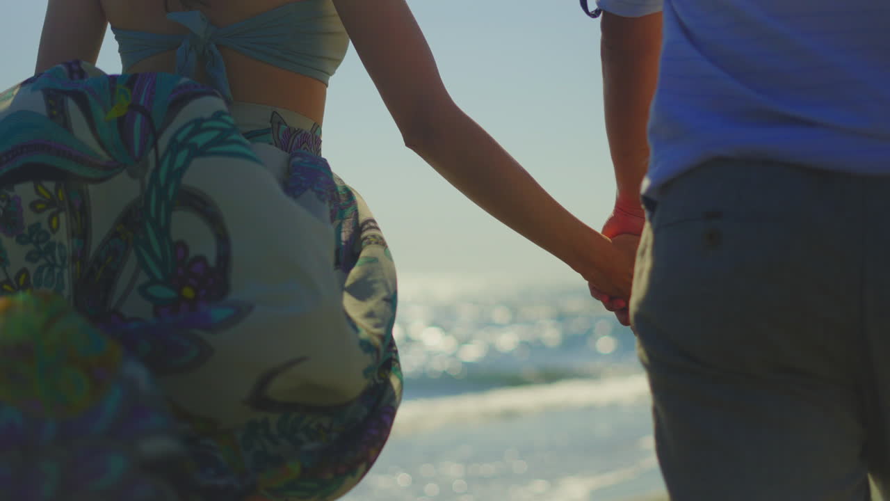 Una pareja de manos en la playa.