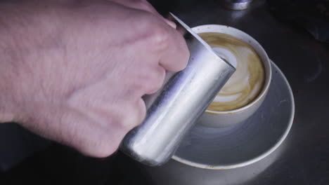 4k barista pouring milk into coffee, latte art