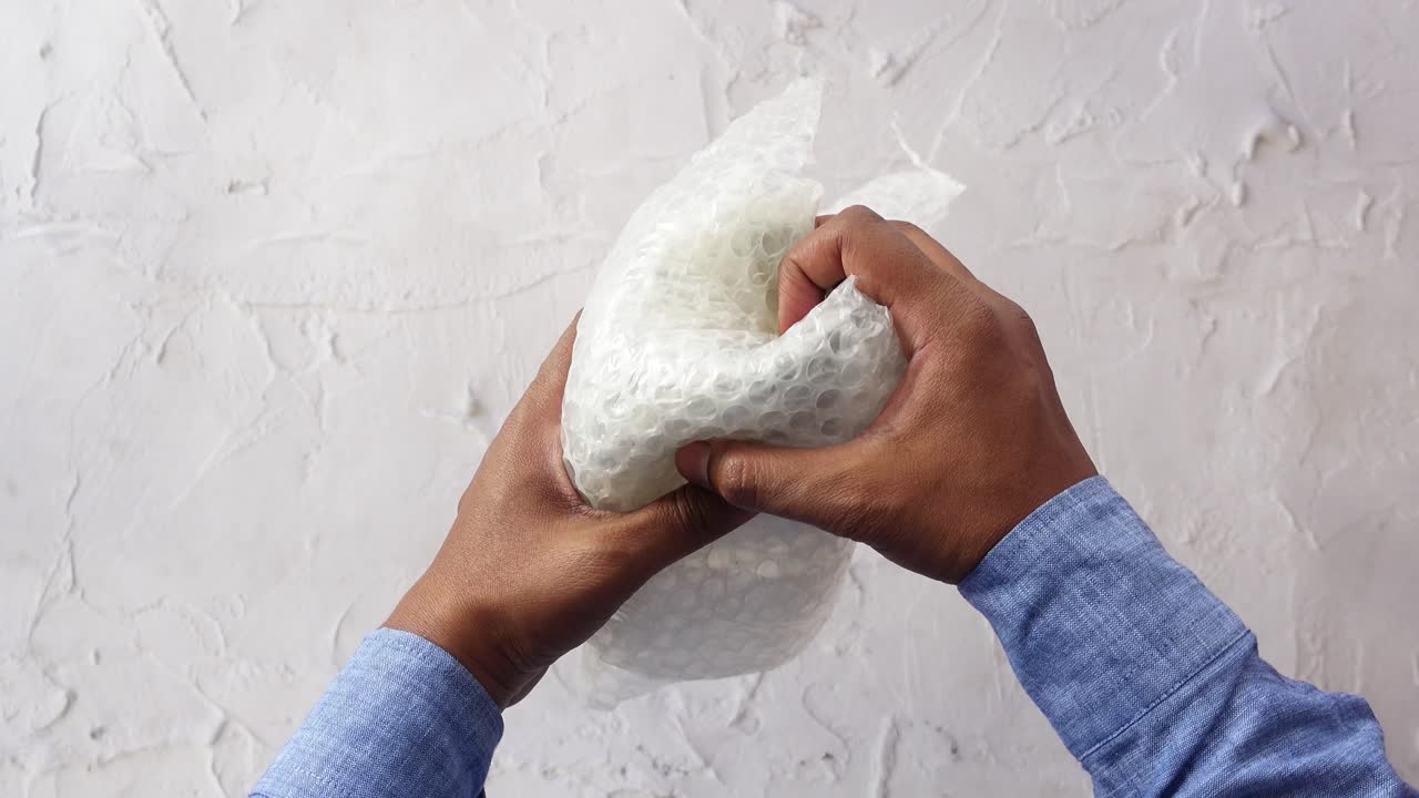 Hands interacting with bubble wrap for packaging