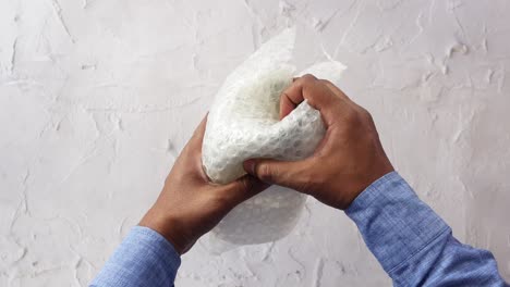 hands interacting with bubble wrap for packaging