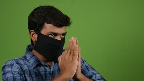 Ein-Junger-Inder,-Der-Eine-Maske-In-Einem-Grünen-Bildschirm-Trägt