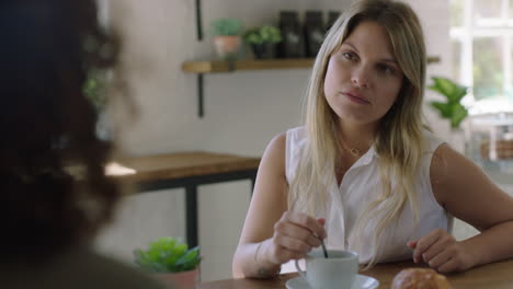 beautiful-woman-in-cafe-talking-to-friend-drinking-coffee-enjoying-relaxed-conversation-chatting-together-socializing-in-restaurant-shop