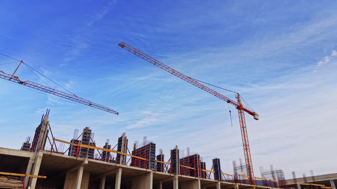 Construction site aerial view with cranes under a clear blue sky