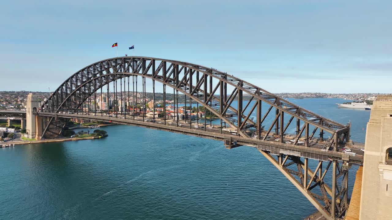toma aérea cinematográfica panorámica desde el puente del puerto de sídney, debajo del puente para revelar la ópera de sídney, punto de referencia de sídney al atardecer, australia