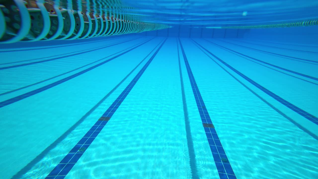 Olympisk svømmebassin under vandbaggrund.