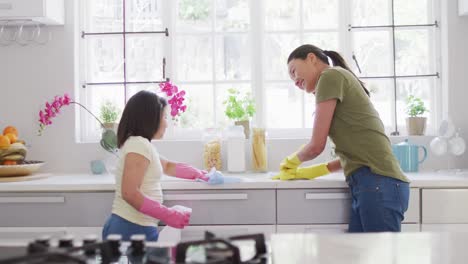 Video-of-happy-asian-mother-and-daughter-cleaning-kitchen