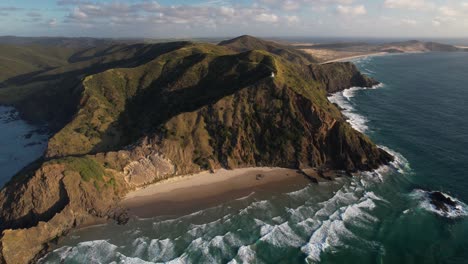 Cape-Reinga-Lighthouse-on-scenic-coastal,-famous-travel-destination-in-New-Zealand---aerial-panoramic