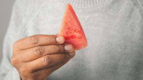person holding a slice of watermelon