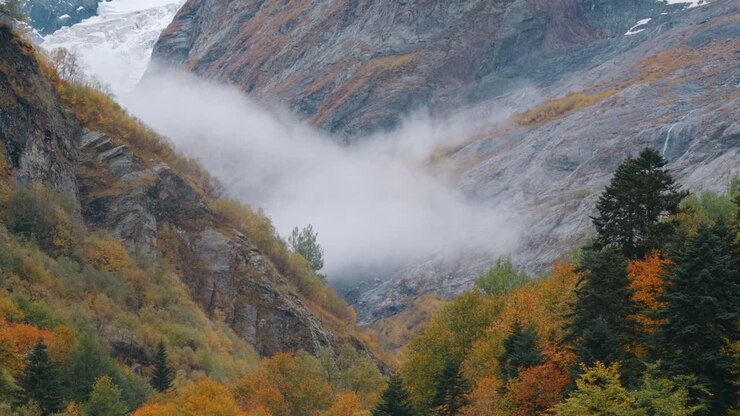 nebbia autunnale in valle di montagna con ghiacciaio