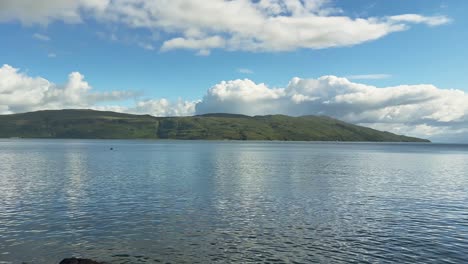 serene sea and port town on the isle of skye, scotland. panning shot